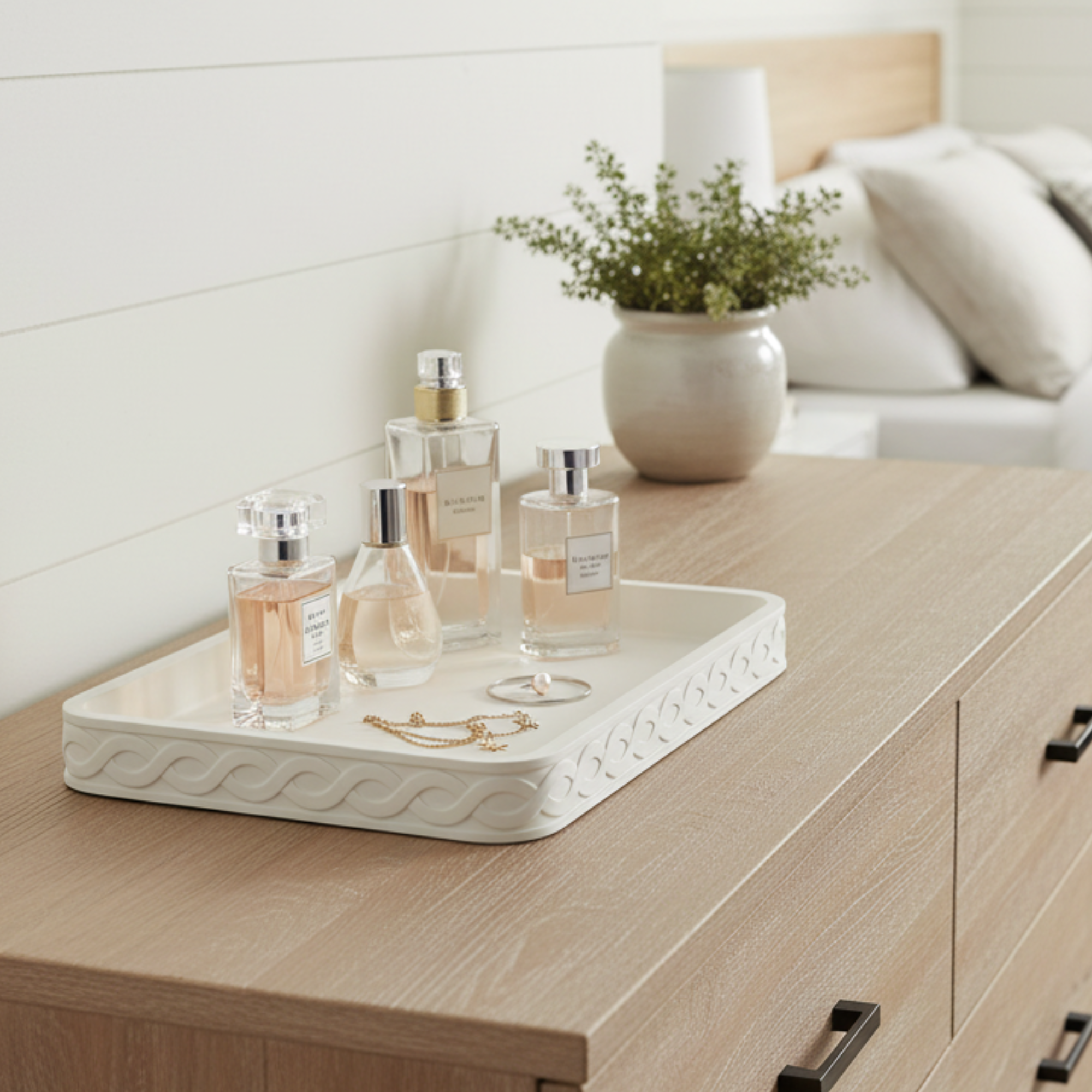 Decorative tray on a bedroom dresser with perfume and jewelry