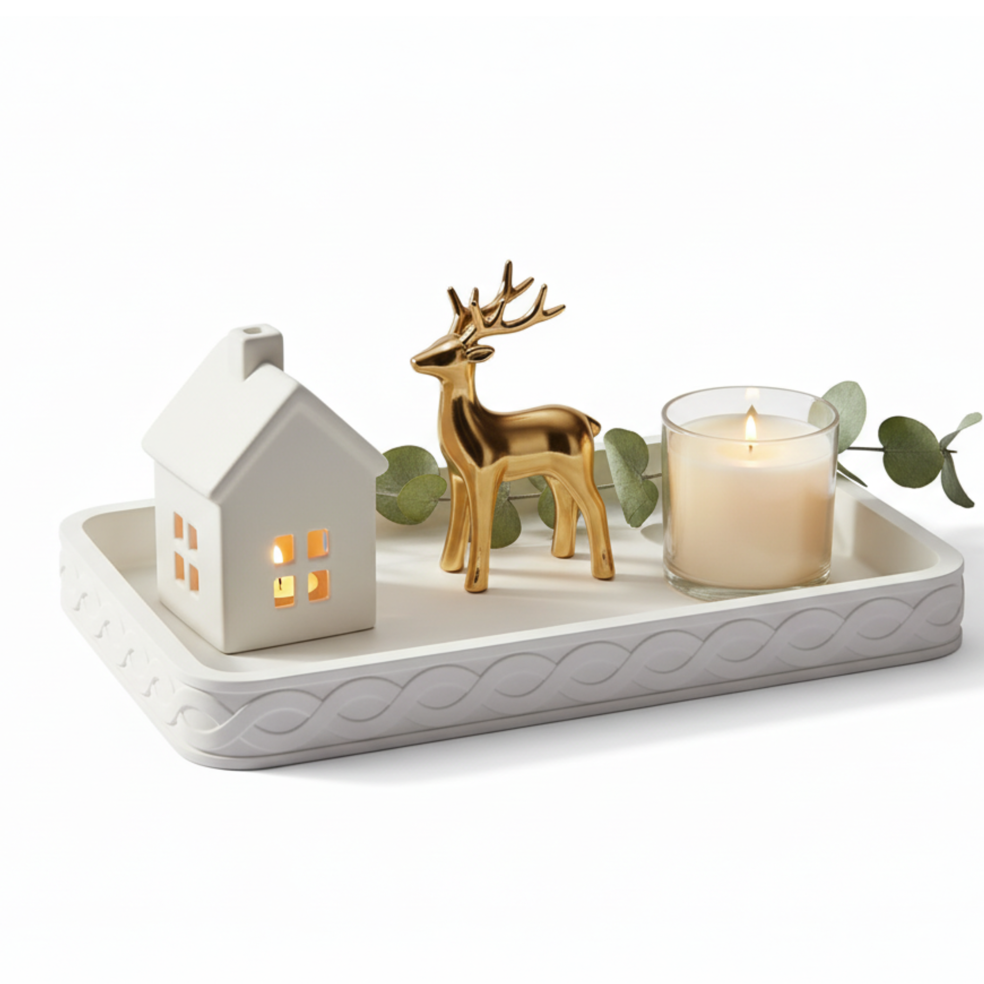 Decorative tray styled with a ceramic house, gold reindeer, and candle